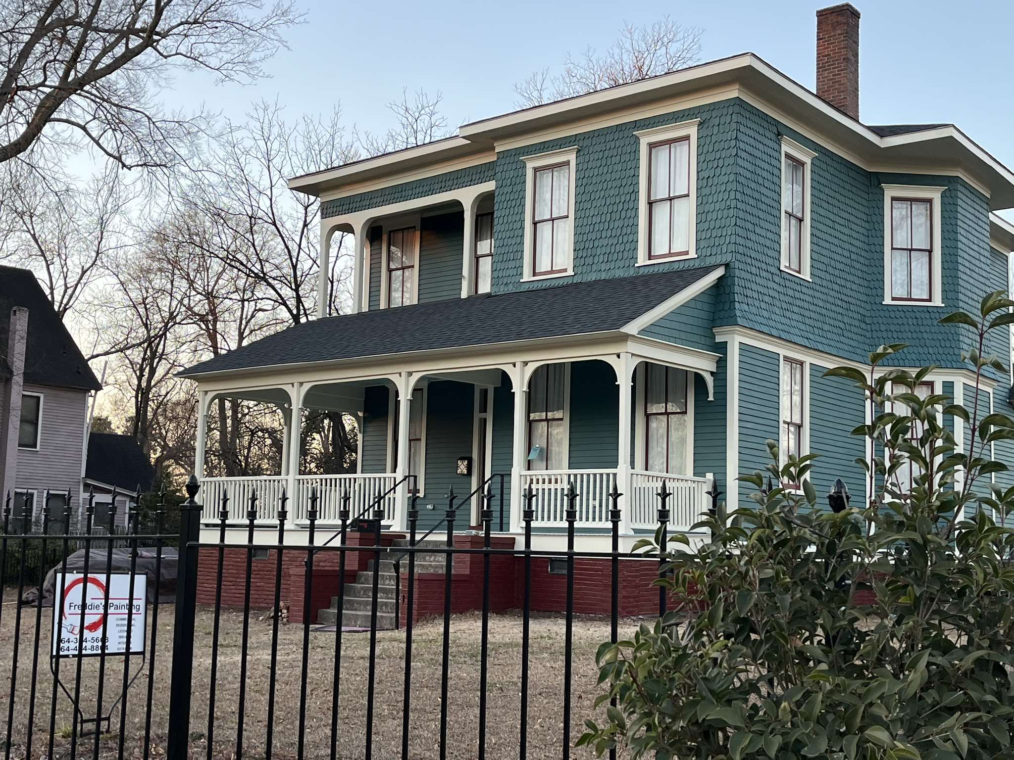 Angled street view of the completed historic exterior behind the front fence