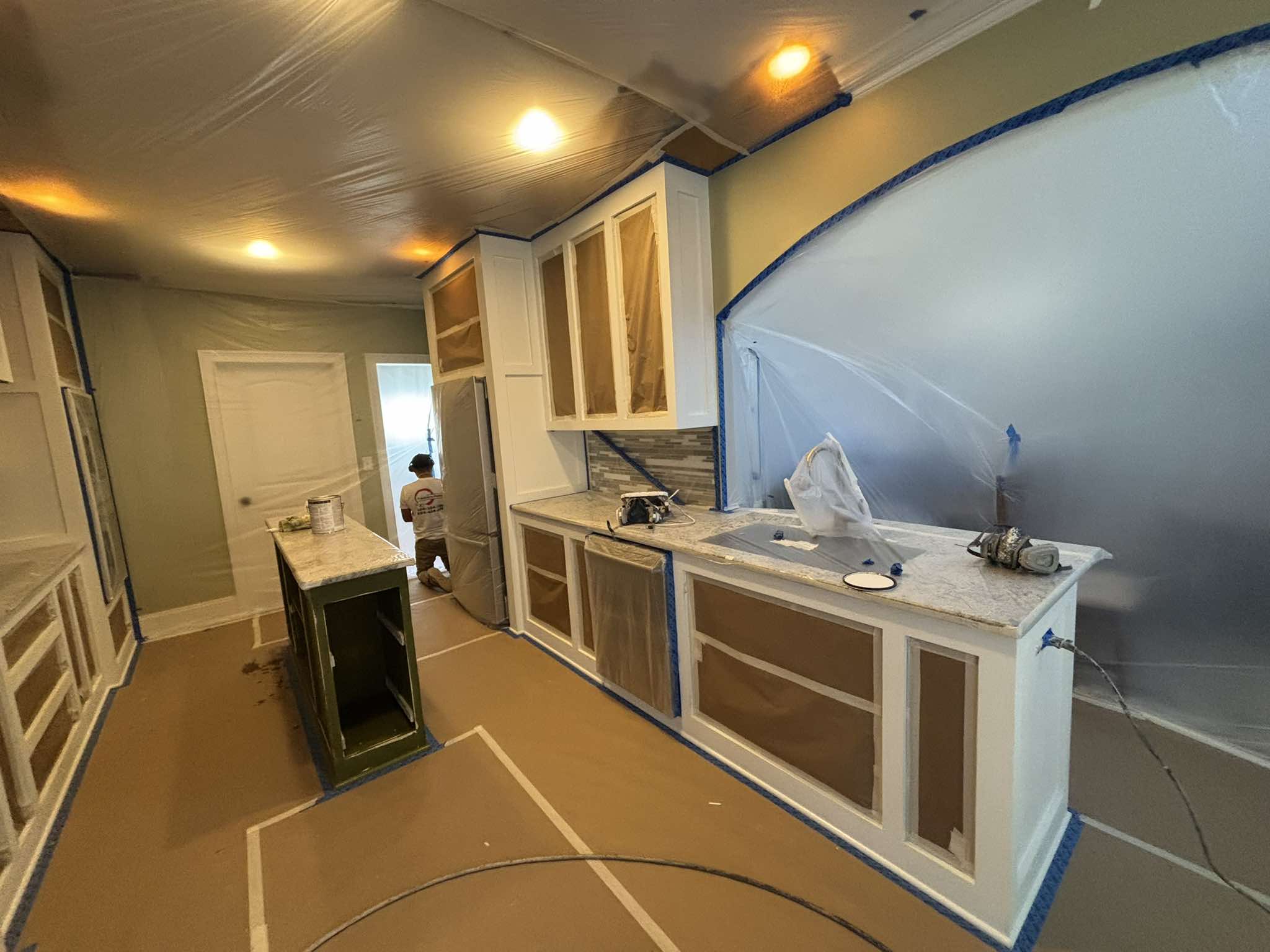 Cabinet boxes and island protected during preparation for the painted finish
