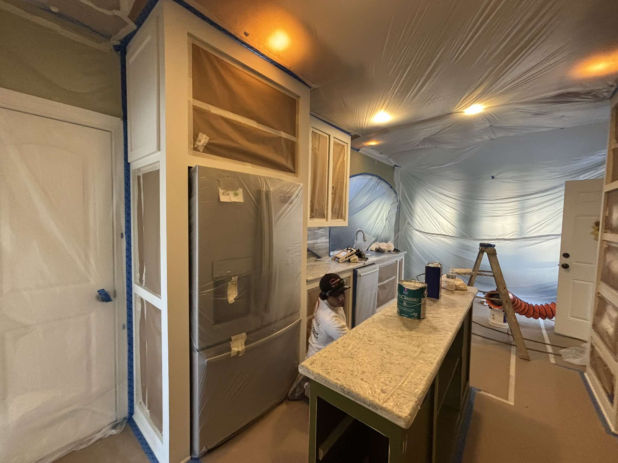 Preparation around the stainless refrigerator, cabinet openings, and center island